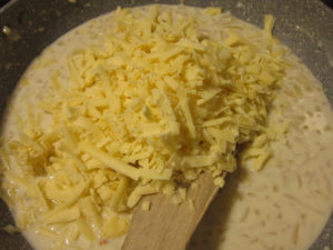 Pile of cheese added to the sauce mixture.